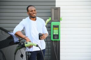 man standing near electric car